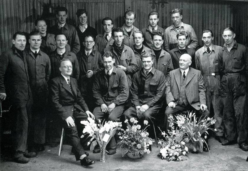 Groepsfoto bij het vijfjarig bestaan op 18 maart 1951 met Jan Duyvis en Piet Kramer (resp. 2e en 3e van onder), Berend Kingma (achterste rij, 2e van links) en Jaap Mooij (middelste rij, 4e van rechts) Groepsfoto personeel bochtbandtransporteur fabriek in Zaandam